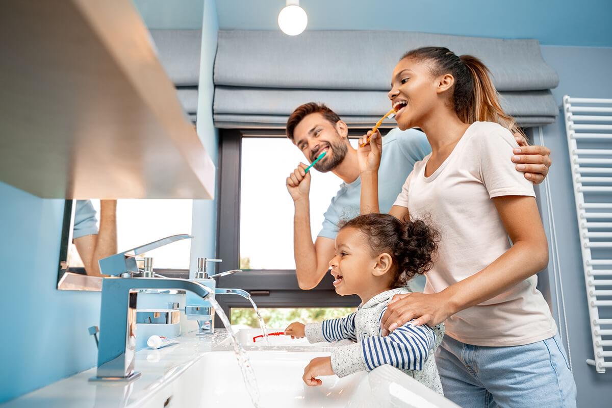 a family brushing their teeth together