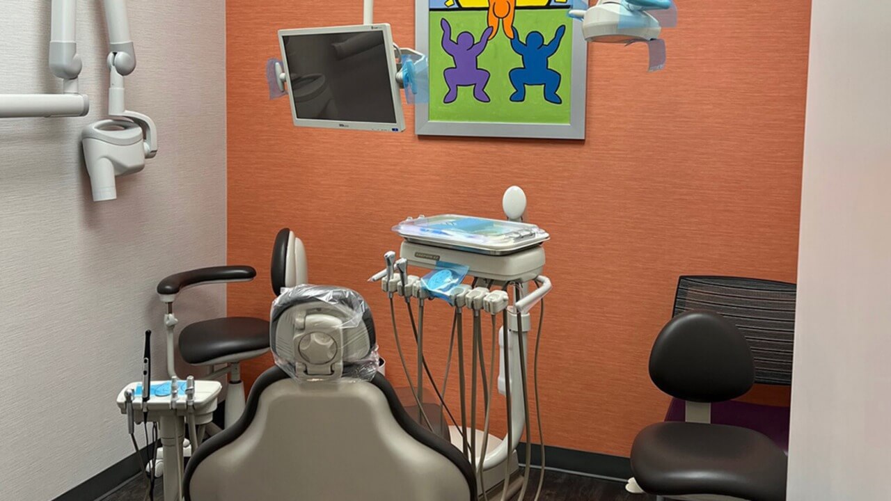 pediatric dental chair with flatscreen tv and art on the wall