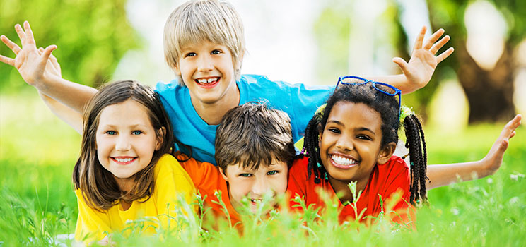 smiling kids play in the grass